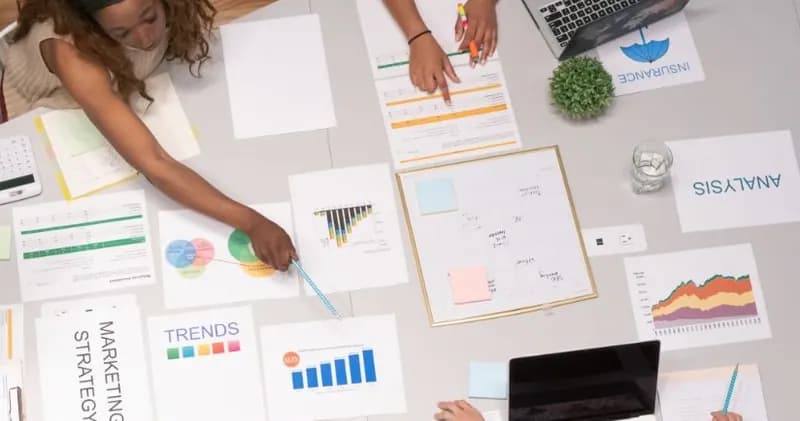 Colleagues at a table covered with charts and planning papers