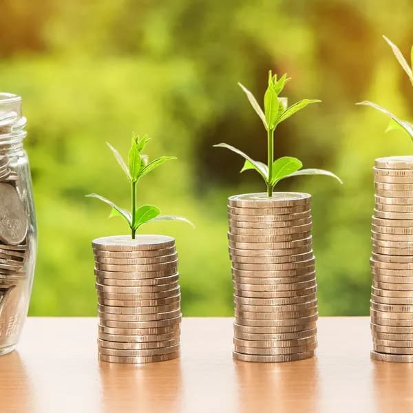 Seedlings growing from stacks of coins