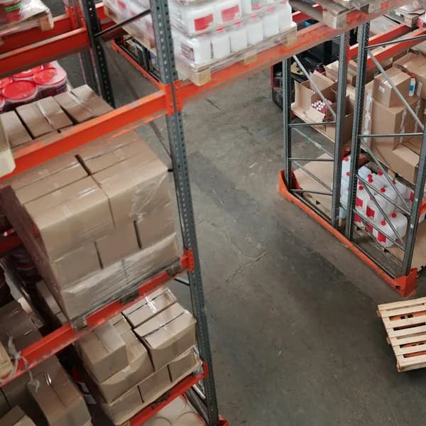 Workers between tall shelves in a warehouse